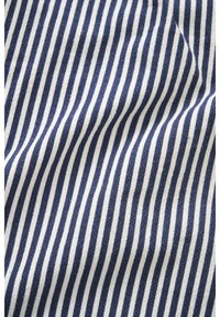 Gros plan sur un tissu à rayures verticales bleu marine et blanches, avec de légers plis visibles sur la surface.