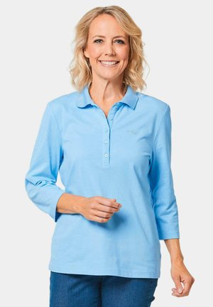 Lichtblauw poloshirt met een drieknoopsluiting, lange mouwen en een klein geborduurd logo op de borst. Gemaakt van zachte stof.