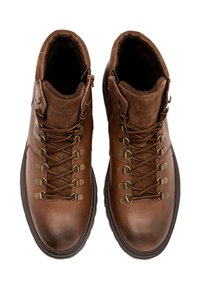 Brązowe skórzane buty turystyczne z teksturowanym wykończeniem, z metalowymi hakami, wyściełanym kołnierzem oraz sznurowadłami. Podeszwa ma surowy design dla lepszej przyczepności.