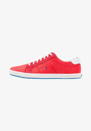 Sneakers in tessuto rosso con lacci bianchi, un tallone bianco a contrasto e una suola in gomma blu. Presentano una patch con logo sul lato.