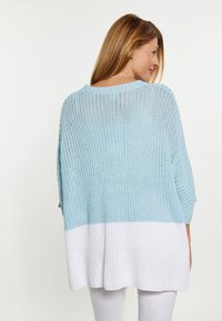 Maglione leggero in maglia con la parte superiore blu e la parte inferiore bianca. Presenta una vestibilità ampia, maniche a tre quarti e un colletto rotondo.