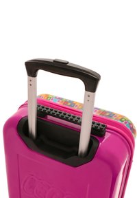 Rosa hård resväska med ett svart teleskophandtag och färgglad dragkedjedetalj med prickar. Har ett strukturerat grepp och präglad logotyp.