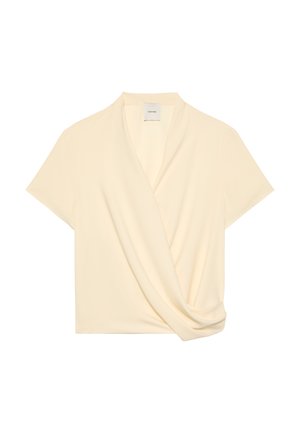 Μπλούζα σε κρεμ απόχρωση με κοντά μανίκια, μπροστινή σχεδίαση τύπου wrap και διακριτική πινελιά ντραπέ, με V-λαιμόκοψη και ελαφρύ ύφασμα.