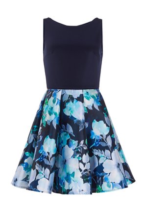 Mouwloze jurk met een aansluitende marineblauwe lijfje en een wijd uitlopende rok. De rok heeft een bloemenpatroon in tinten blauw, teal en groen.