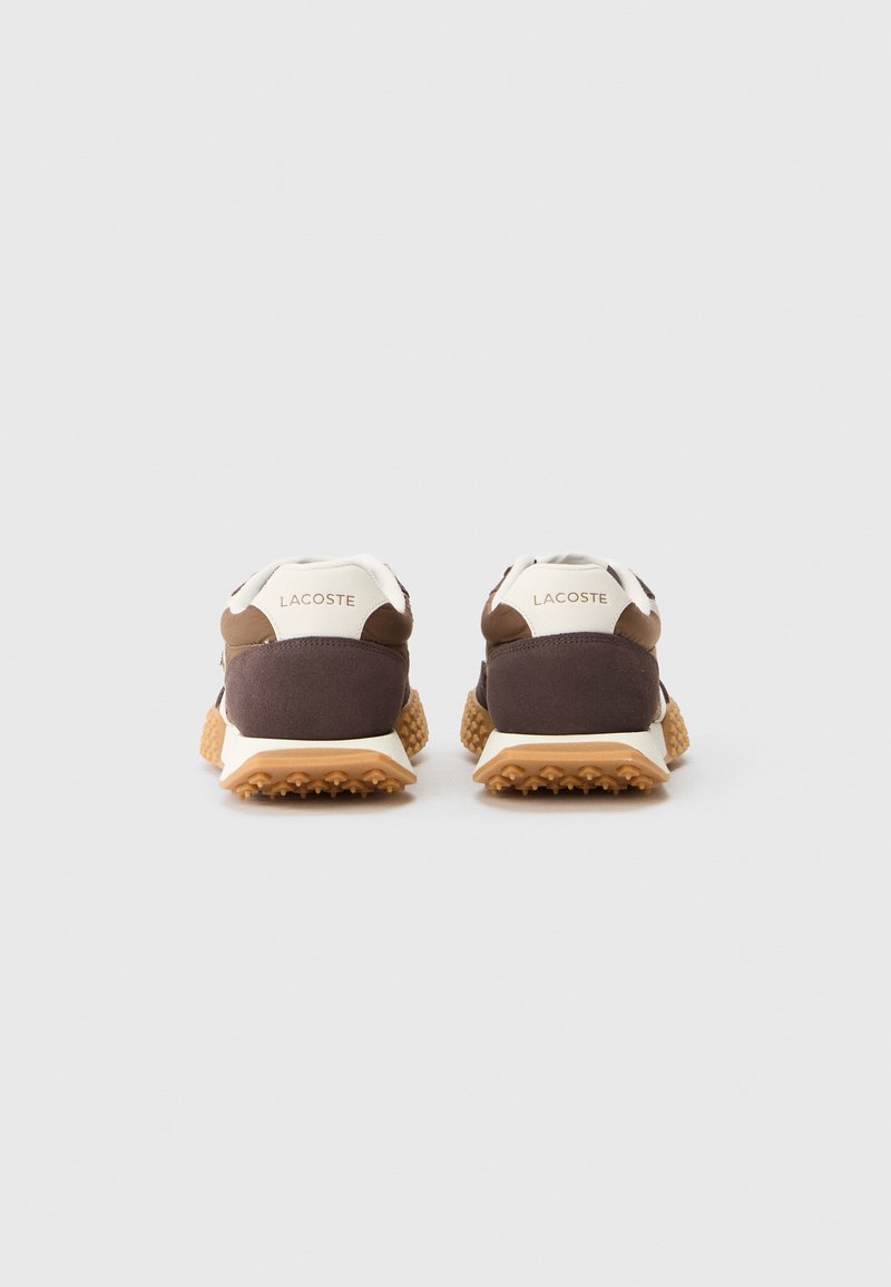 Zapatillas Lacoste con parte superior de textil marrón con acentos blancos, suela de goma texturizada y sutil branding en el talón.
