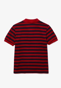 Kortärmad pikétröja med röda och marinblå horisontella ränder, röd krage, visad från baksidan mot en enfärgad vit bakgrund.