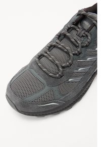 Men's gray athletic shoe with a textured mesh upper, suede accents, and reflective detailing, featuring a padded tongue and lacing system.