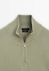 Lichtgroene pullover met rits van zacht katoen. Heeft een geribbelde kraag en zoom, met een metalen rits en een label aan de binnenkant.