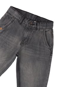 Jeans de mezclilla gris con un acabado desgastado, diseño de cinco bolsillos y cierre de botón. La cinturilla cuenta con pasadores para cinturón y un pequeño parche con el logo.