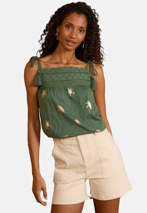 Grøn ærmeløs top med broderede palmer, scalloped blondekant og frynset bindebånd. Sammen med beige højtaljede shorts i glat tekstur.