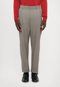 Gray pleated trousers made of lightweight fabric. Features a tailored fit and straight leg design. Worn with black shoes and a red sweater.