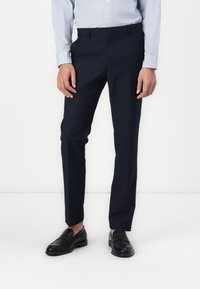 Navy dress pants with a tailored fit, lightweight fabric, and a smooth texture. Features flat front, side pockets, and a standard waistband.