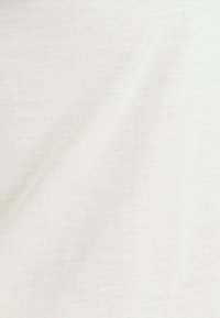 Tela blanca, texturizada con un patrón sutil y desigual. Material suave y ligero con un aspecto liso.