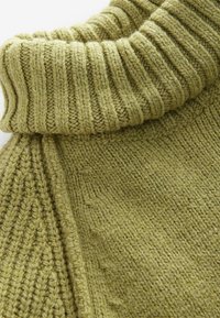 Olive green knitted sweater featuring a ribbed turtleneck and textured weave, showcasing varied patterns in the knit design.