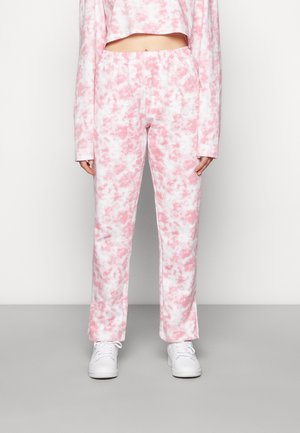 Suanças leves com efeito mármore rosa e branco, com um cós elástico, combinadas com sapatilhas brancas. Design casual e ajustado.