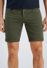 Olijfgroene katoenen shorts, slim fit, met opgerolde manchetten, voorzakken en riemlussen. Gladde textuur met subtiele stikseldetails.