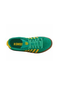 Zielone zamszowe sneakersy K-Swiss z żółtymi paskami, pasującymi sznurowadłami, brązową podeszwą oraz logo na języku i wkładce.