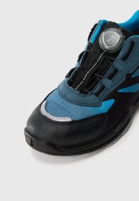 Schwarzer und blauer Sportschuh mit einer strukturierten Oberseite, ausgestattet mit einem runden BOA-Schnürsystem, verstärkter Zehenpartie und einem subtilen grauen Akzent.