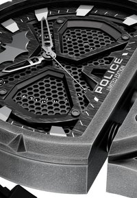 Črno uro s heksagonalnimi izrezi, teksturirano sivo ohišje, drzne kazalce in angularni markerji. Ima značilni simbol netopirja. Omejena izdaja.