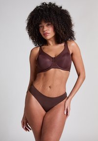 Rudas liemenėlė ir atitinkantis bikini, pagaminti iš lygaus audinio. Liemenėlė pasižymi struktūrine konstrukcija, reguliuojamais dirželiais ir užsegimu.