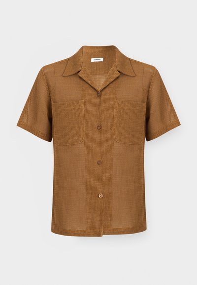 Καφέ πουκάμισο με κοντά μανίκια και κουμπιά, με υφή ανοιχτής ύφανσης, δύο μπροστινές τσέπες στο στήθος και μυτερό γιακά.
