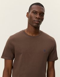 Brun bomulds T-shirt med korte opsmøgede ærmer og et lille blåt "II" logo på brystet. Rund halsudskæring, blød tekstur.