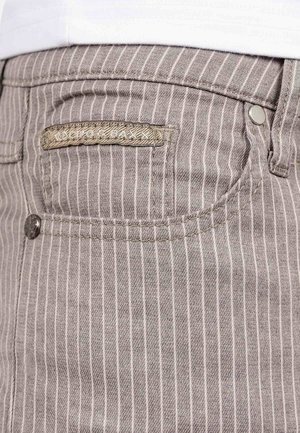 Jeans in denim a righe marroni con un'etichetta tessuta sulla tasca posteriore e un dettaglio con bottone argentato, che mettono in mostra un tessuto testurizzato.