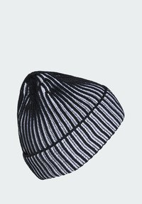 Gorro de punto con rayas negras y blancas y puño doblado, mostrado sobre un fondo gris claro liso.
