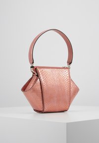 Metallinen vaaleanpunainen käsilaukku, jossa on teksturoitu käärmeennahkakuosi, kolmiomainen muoto ja ohut, kuviollinen olkahihna. Varustettu vetoketjulla ja kulmikkaalla muotoilulla.