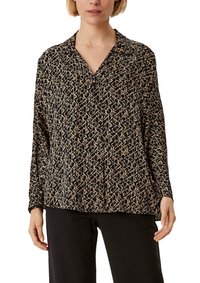 Blusa nera con un motivo geometrico in beige, dotata di maniche lunghe e colletto a punte. Realizzata in tessuto leggero per un fit rilassato.
