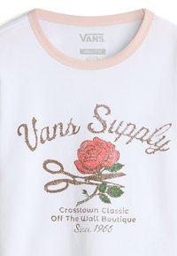 Vit bomull t-shirt med en ljusrosa krage, med en glittrande ros grafik och dekorativa saxar i brunt, rött och grönt.