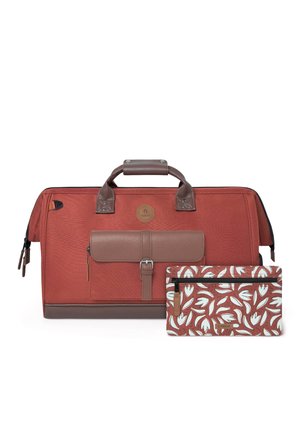 Sac de voyage couleur rouille avec poignées en cuir marron et une poche avant à côté d'une petite pochette zippée assortie à motif floral.