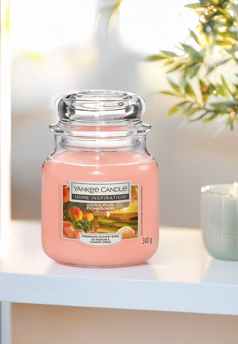 Yankee Candle, stor glasbehållare, rosa vax, etikett med frukt och natur, silverlock, 340 g kapacitet, placerad på en vit hylla.