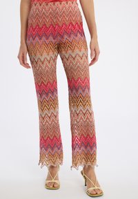 Meerkleurige zigzagpatroon broek met een losse pasvorm, met een golvend ontwerp in tinten van oranje, roze en blauw. Transparante stof met een komstige zoom.