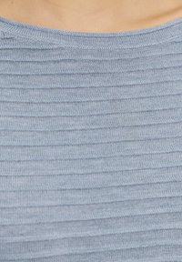 Hellblaues Strickshirt mit einem strukturierten, gestreiften Muster und weitem Ausschnitt. Der Stoff wirkt weich und leicht elastisch.