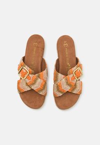 Braided fabric sandals in orange, beige, and brown, featuring a cross strap design and a golden buckle accent on a beige footbed.