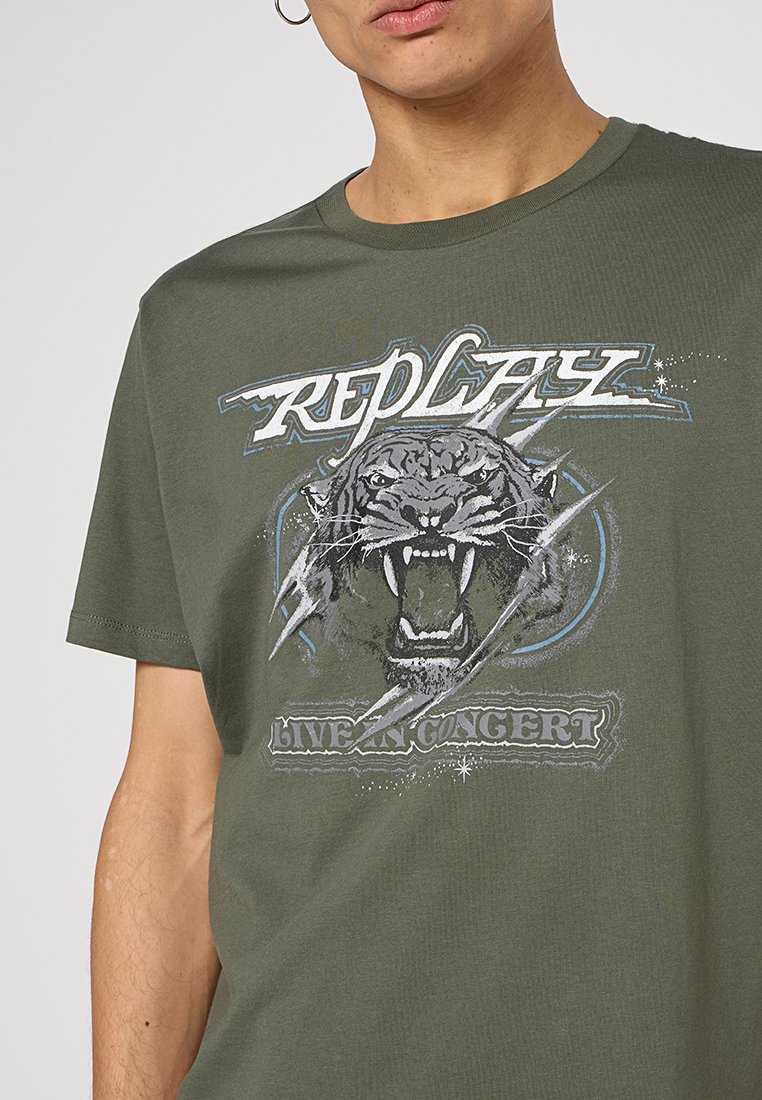 Olijfgroene katoenen t-shirt met een grafische print van een brullend tijgerhoofd, bliksemschichten en de tekst "REPLAY LIVE IN CONCERT."