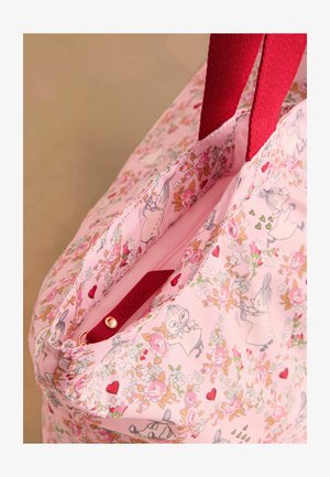 Roze tas met een bloemen- en cartoonpatroon, voorzien van rode handvatten en een ritssluiting. Binnenzijde van het label zichtbaar.