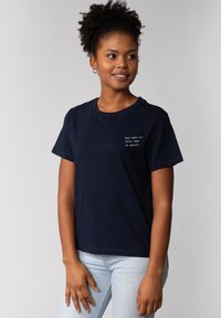 Marineblauwe katoenen t-shirt met korte mouwen, een ronde halslijn en witte tekst op de borst. Heeft een ontspannen pasvorm en een zachte textuur.