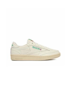 Baskets Reebok profil bas de couleur blanc cassé avec logo vert sur le côté, semelle crème, et laçage à l’avant, vues de côté extérieur.