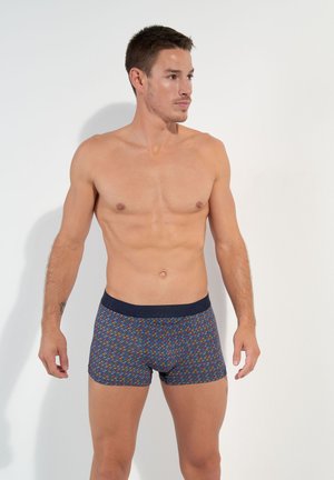 Boxershorts mit einem mehrfarbigen Zickzackmuster und einem marineblauen Bund. Hergestellt aus elastischem Stoff, bieten sie eine enge Passform und eine weiche Textur.