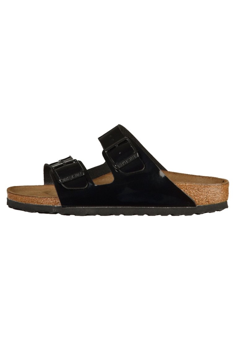 Svarta patentlädersandaler med två justerbara remmar, korkfot säng och gummisål, som har en slät yta och minimalistisk design.