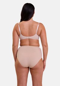 Ensemble de soutien-gorge beige et de culotte taille haute. Tissu lisse avec bretelles réglables et fermeture à crochets. Texture douce, sans motifs ni accents.