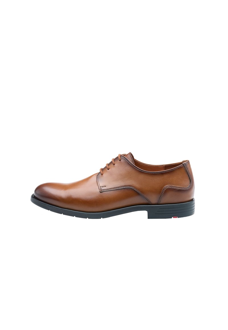 Bruine leren veterschoen met een ronde neus, subtiele stikdetails en een zwarte rubberen zool. Platte veters en minimale ontwerpaccenten.