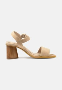 Sandale din suede bej, cu două curele late și o talpă interioară căptușită. Dispune de un toc din lemn curbat. Talpa galbenă.