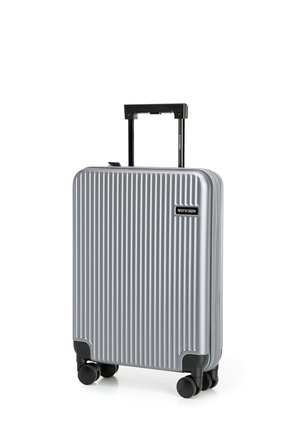 Silver hard-shell suitcase with vertical grooves, black wheel accents, and a retractable handle. Brand label on front.