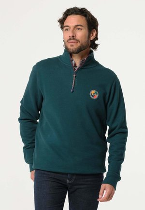 Donkergroene sweatshirt met ritssluiting en opstaande kraag, gemaakt van zachte stof, met een geborduurd logo op de borst en een gegoten binnenkraag.
