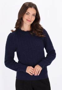 Dunkelblauer Strickpullover mit einem strukturierten Zickzackmuster, Rundhalsausschnitt und gerippten Bündchen und Saum. Figurbetonte Silhouette, weicher Stoff.