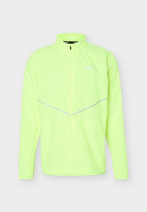 Giacca sportiva a maniche lunghe di colore giallo neon con zip frontale completa, collo alto, dettagli riflettenti e piccolo logo Nike sul petto.