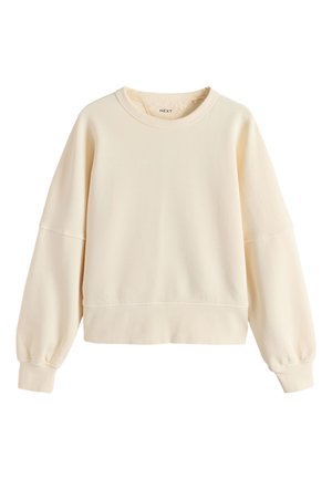 Krém színű környakas pulóver hosszú ballon ujjakkal és bordázott mandzsettákkal, valamint alsó résszel, egyszerű, hétköznapi stílus.